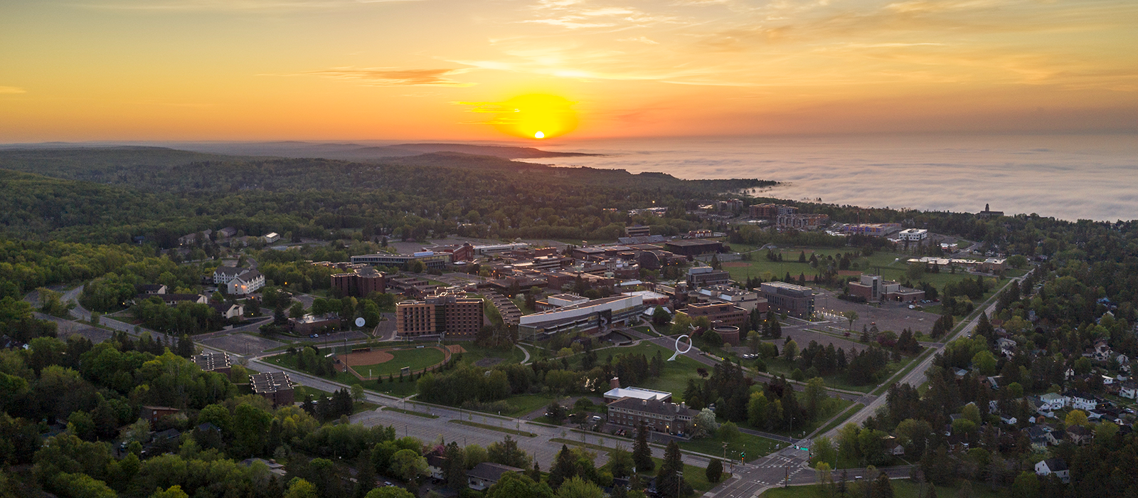 Sunset aerial shot of UMD campus and Lake Superior