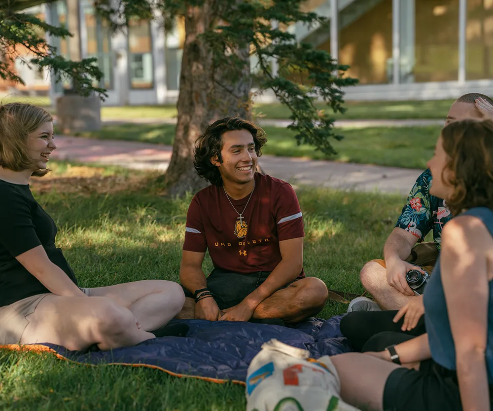 Group of students sitting outside on campus.