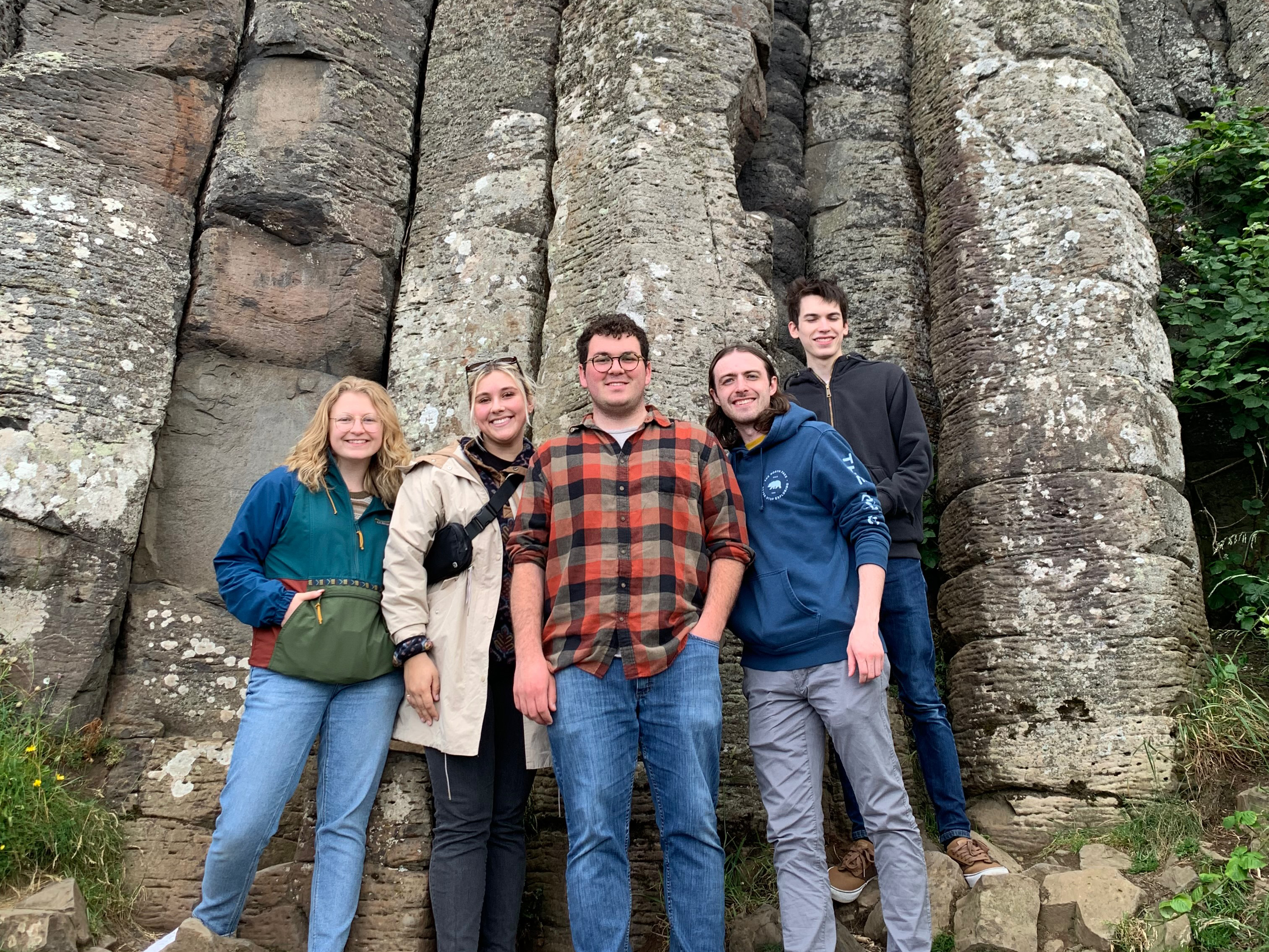 A group of 5 UMD students in front of a rock wall during their study abroad trip to Dublin