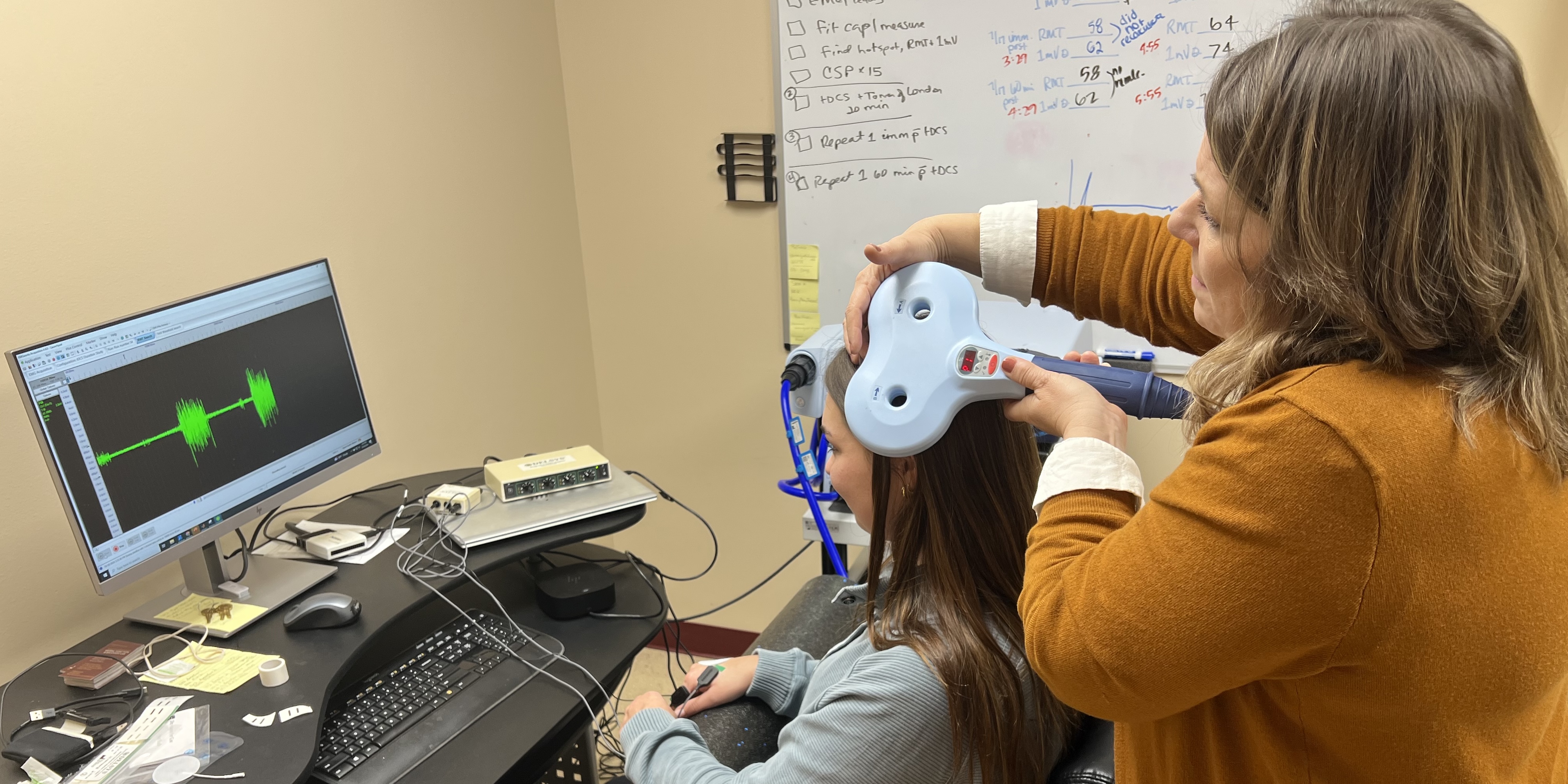 Sheryl Samargia Grivette using the TMS machine on a student 